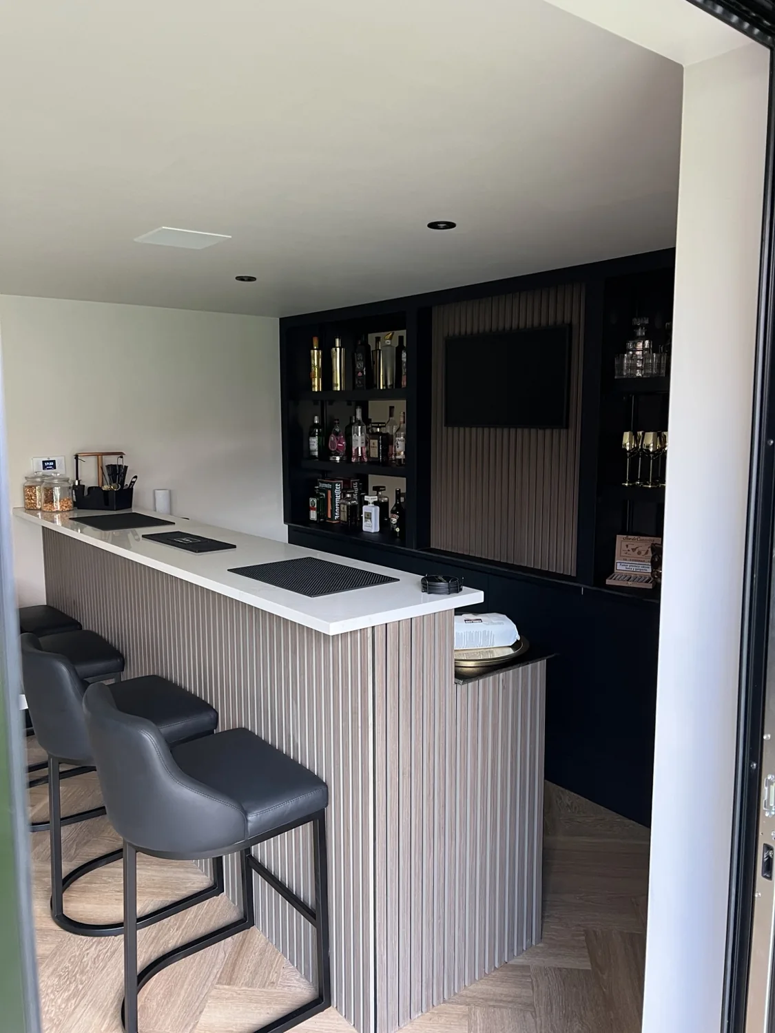Bespoke home bar with timber slat front and seating
